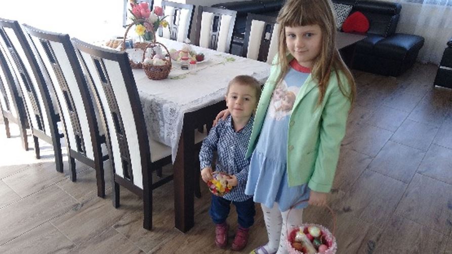 Dziewczynka z chłopczykiem stoją przy stole