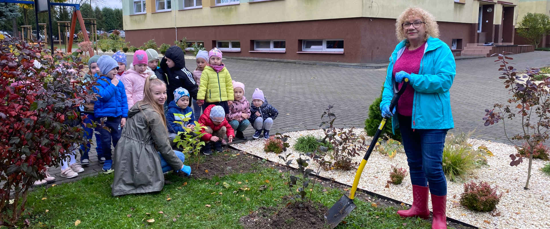 Przedszkolaki z opiekunami sadzą drzewka
