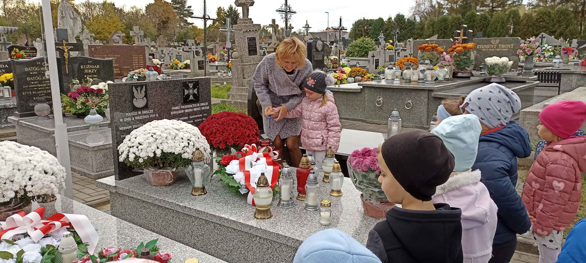 Dzieci przy pomniku na cmentarzu