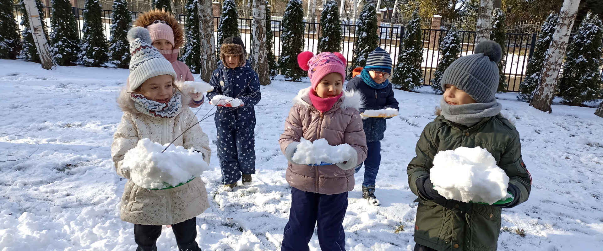 Dzieci trzymają śnieg w rękach