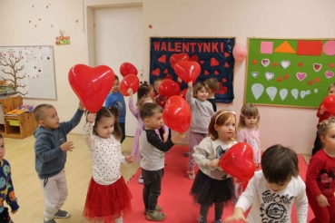 Dzieci z czerwonymi balonami podczas zabawy walentynkowej