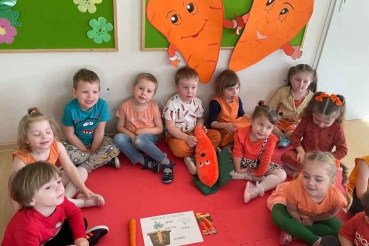 Dzieci siedzą na wykładzinie