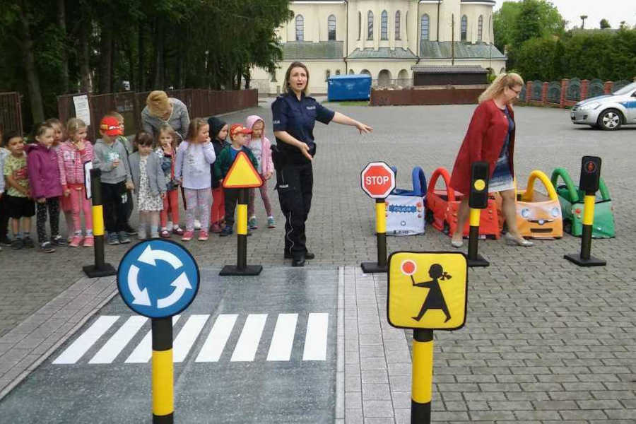 Policjantka z przedszkolakami uczy zasad ruchu drogowego