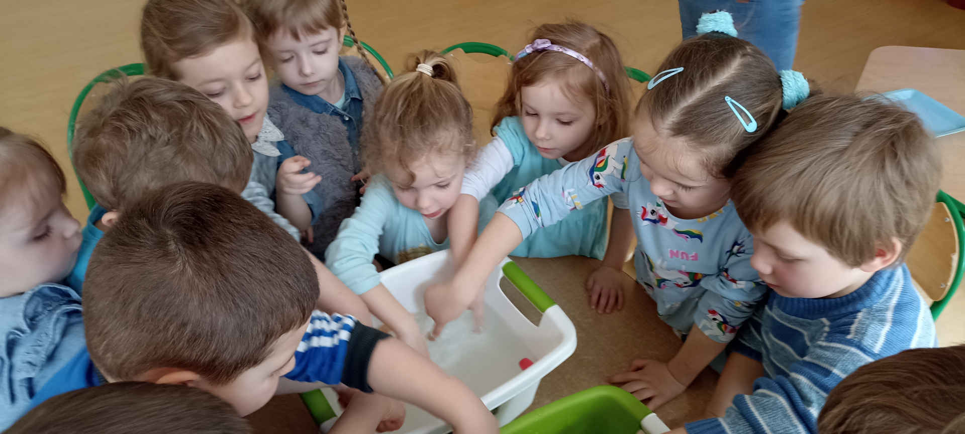 Dzieci z rękami w wanience z wodą