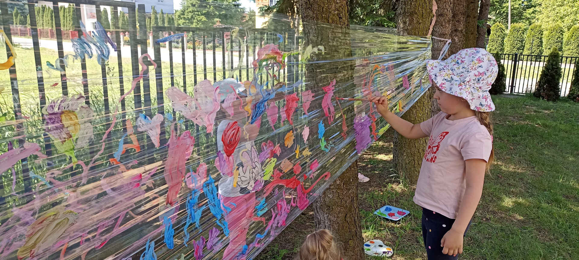 Dziewczynka maluje farbami na folii