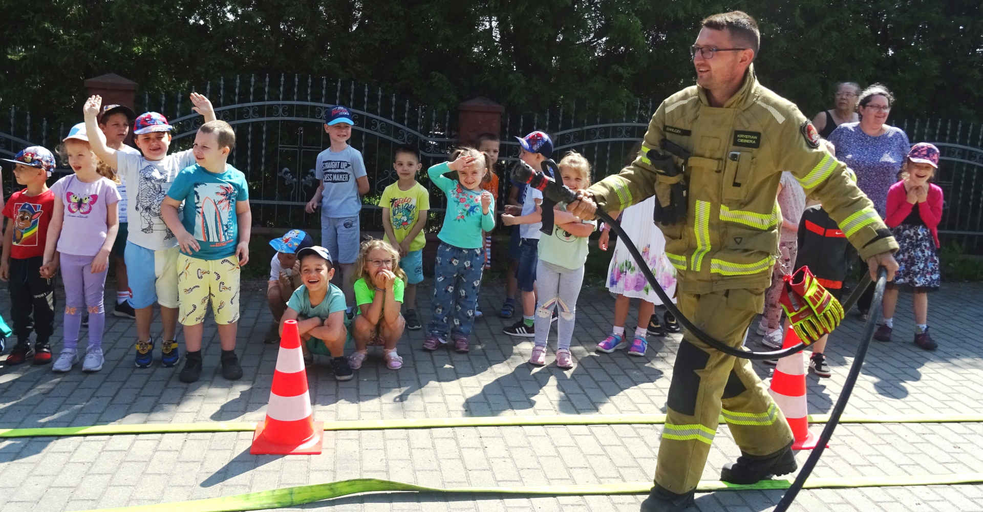 Strażak pokazuje przedszkolakom system gaśniczy